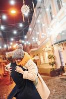 casal tem um passeio juntos na rua decorada de natal foto