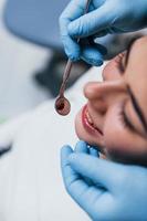 vista de perto de uma jovem adulta que tem uma visita na clínica odontológica. concepção de estomatologia foto