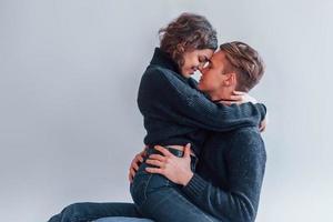 casal jovem bonito se abraçando dentro de casa no estúdio foto