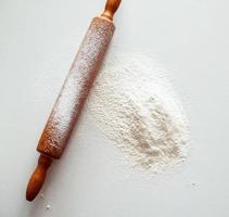 rolo de massa com farinha de trigo branca foto