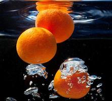três laranjas na água foto