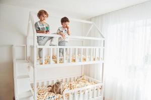 dois garotinhos descansando e se divertindo dentro de casa no quarto juntos foto