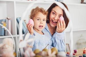 mãe com filha comemorando as férias de Páscoa juntos. segurando os ovos nas mãos foto