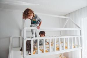 dois meninos descansando e se divertem juntos no quarto. gato sentado perto deles foto