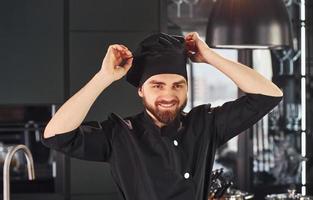 cozinheiro profissional jovem chef de uniforme em pé na cozinha foto