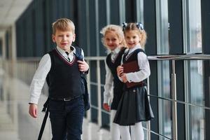 crianças da escola de uniforme juntos no corredor. concepção de educação foto