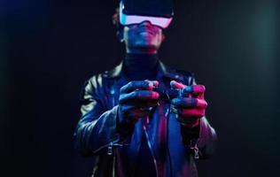 experiência de realidade virtual. iluminação neon futurista. jovem afro-americano no estúdio foto
