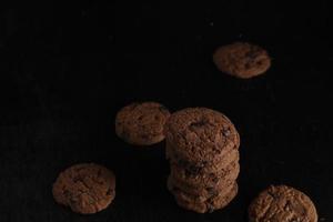 biscoitos de chocolate em fundo preto foto