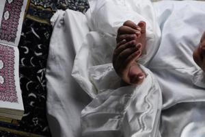 mão de criança rezando com as mãos levantadas contra o fundo do Alcorão. conceito islâmico foto