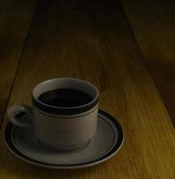 xícara de café preto em um fundo de madeira. área de cópia foto