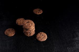 biscoitos de chocolate em fundo preto foto