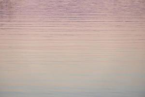 pôr do sol cor de rosa rosa sobre um lago no outono foto