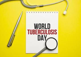 palavras do dia mundial da tuberculose no notebook e estetoscópio em fundo amarelo foto