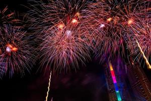 comemoração de ano novo, multidão e fogos de artifício coloridos perto do rio, tailândia foto