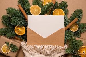 um cartão para texto dentro do saco de barbante em ramos de abeto decorado com frutas cítricas secas e canela. zero desperdício de férias de inverno. foto