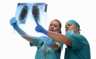 radiologistas femininos e médico masculino verificando o raio x do paciente. isolado no fundo branco foto