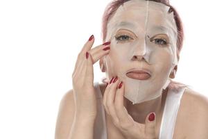 procedimento cosmético. rosto de mulher com máscara cosmética branca foto