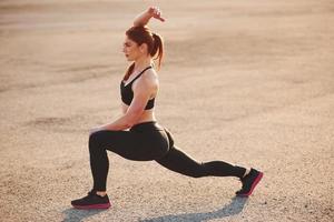 mulher em roupas esportivas tem dia de fitness na estrada à noite foto