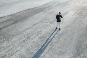 visão superior do homem que está parado na estrada à noite sozinho e olhando para o relógio foto