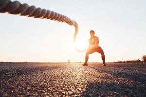 mulher em treinamento esportivo com nós na estrada ao entardecer foto