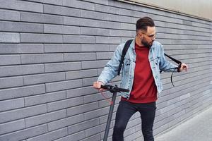 cara jovem bonito em roupas casuais andando de escuna elétrica ao ar livre durante o dia ensolarado foto