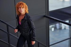 jovem ruiva europeia em roupas esportivas em pé ao ar livre foto