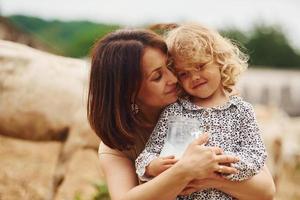 leite natural fresco. jovem mãe com sua filha está na fazenda no verão foto