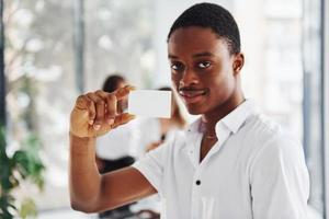 jovem afro-americano em roupas formais está no escritório foto