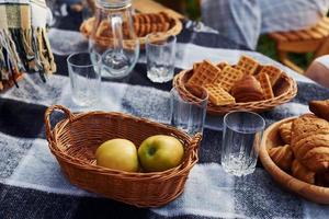 vista superior da mesa de piquenique com maçãs, doces e copos vazios foto