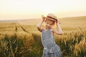 menina de pé no campo agrícola ao entardecer. concepção de tempo livre de verão foto