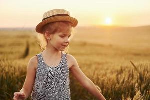 menina de pé no campo agrícola ao entardecer. concepção de tempo livre de verão foto