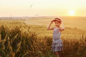 menina de pé no campo agrícola ao entardecer. concepção de tempo livre de verão foto