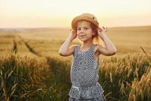 menina de pé no campo agrícola ao entardecer. concepção de tempo livre de verão foto