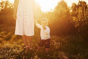 mãe positiva com seu filho passando o tempo livre no campo no dia ensolarado do verão foto