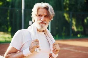 homem estiloso moderno sênior ao ar livre no campo esportivo durante o dia foto