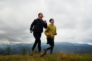 correndo juntos. casal fazendo fitness. majestosas montanhas dos cárpatos. bela paisagem de natureza intocada foto