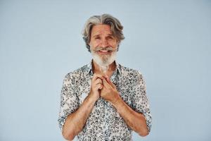 mantém a lâmpada nas mãos. concepção de ideias e inspiração. homem moderno elegante sênior com cabelos grisalhos e barba dentro de casa foto