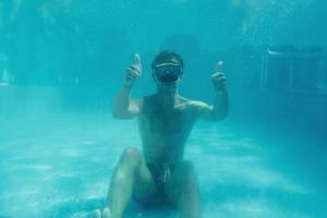 homem nadando debaixo d'água na piscina durante o dia. se divertindo foto