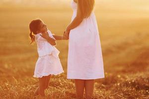 menina positiva com sua mãe tem fim de semana ao ar livre no campo de verão juntos foto