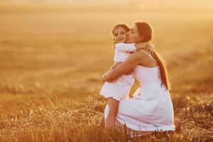 menina positiva com sua mãe tem fim de semana ao ar livre no campo de verão juntos foto