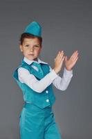 menina bonitinha em uniforme de aeromoça azul está posando para a câmera foto