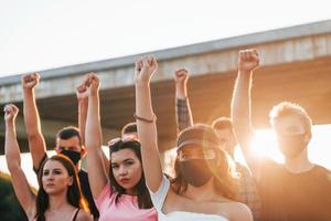 punhos erguidos para o alto. grupo de jovens protestantes que estão juntos. ativista pelos direitos humanos ou contra o governo foto