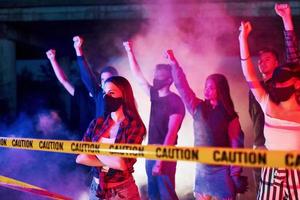 linha de polícia e fumaça. grupo de jovens protestantes que estão juntos. ativista pelos direitos humanos ou contra o governo foto