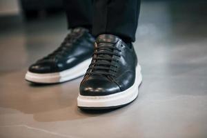 close-up vista das pernas do homem em sapatos pretos de luxo novos e modernos foto