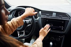 dirigindo carro. mulher jovem e bonita na moda e seu automóvel moderno foto