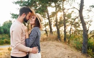 de pé e abraçado. alegre adorável jovem casal descansando ao ar livre juntos foto