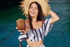 segurando coquetel. garota se divertir e descansar na piscina durante o dia. concepção de férias foto