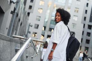 mulher afro-americana com boas roupas está ao ar livre na cidade durante o dia foto