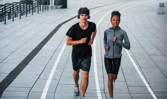 homem europeu e mulher afro-americana em roupas esportivas se exercitam juntos foto