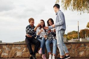 hora do café. grupo de jovens amigos alegres que está ao ar livre se divertindo juntos foto